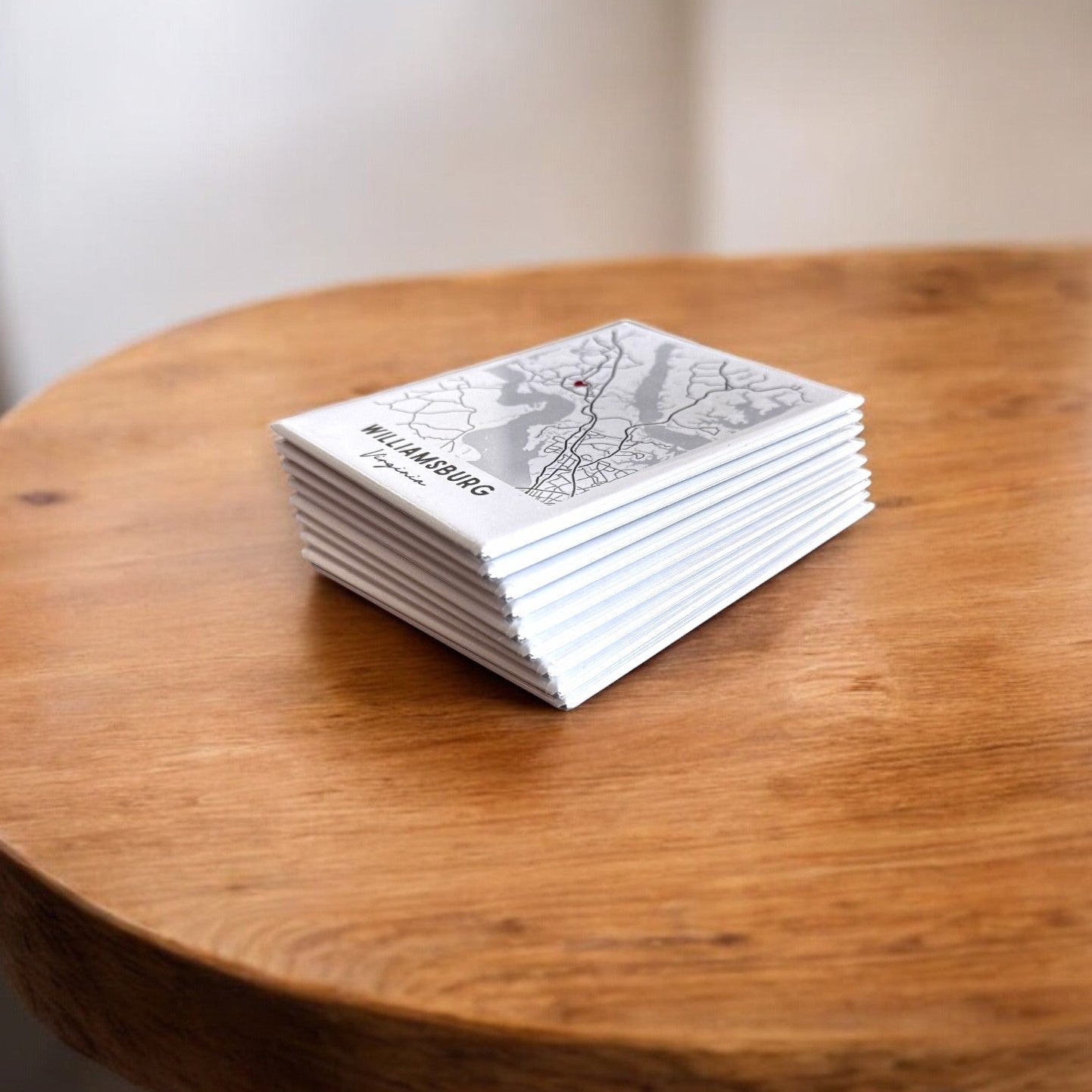 Stack of white magnets with map and black text on a wooden table