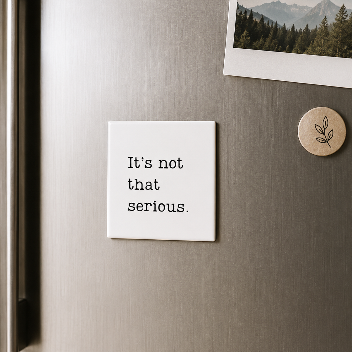 Fridge with a magnet that says 'It's not that serious' and another magnet with a leaf design.